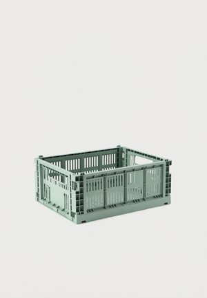 Caisse de rangement rectangulaire en plastique vert avec ouverture en haut et côtés ajourés, posée sur une surface blanche unie.