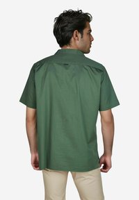 Korte mouwen groene shirt van katoen met een button-down kraag, voorzien van een gladde textuur en een lusdetail op de achterkant.