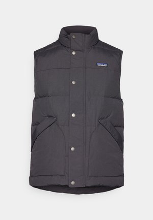 Melnas pūkainas veste ar augstu apkakli, spiedpogu aizdari un sānu kabatām. Tam ir šūtu rakstu un mazs logotips uz krūtīm.