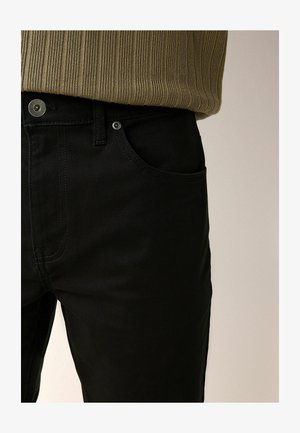 Črne denim hlače s slim fit krojem, sprednjimi žepi in kovinskim gumbom za zapiranje. Gladka tekstura z diskretnimi šivi.
