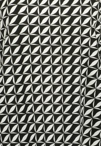Czarny materiał z powtarzającym się geometrycznym wzorem białych kształtów liści ułożonych w formację diamentową, tworzącym kontrast i teksturę.