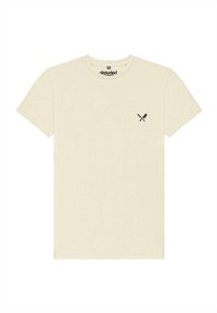 Béžové bavlněné tričko s kulatým výstřihem a krátkými rukávy. Na levé straně hrudi má malý černý motiv zkřížených nožů.