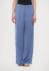 Pantaloni azzurri chiari con una vestibilità rilassata, vita elastica e tessuto dalla trama liscia. Presentano gambe ampie e un orlo pulito.