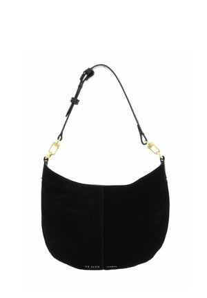 Sac à épaule en daim noir à forme courbe, bandoulière noire réglable avec fermoirs dorés, et petit logo doré Ted Baker London en bas.