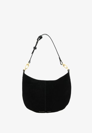 Sac à épaule en daim noir à forme courbe, bandoulière noire réglable avec fermoirs dorés, et petit logo doré Ted Baker London en bas.
