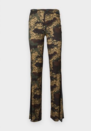 Camo pants in shades of green and brown, made from stretchy fabric, featuring side slits at the hem for added detail and movement.