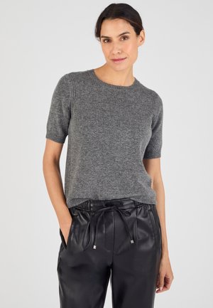Maglione grigio a maniche corte in morbido tessuto a maglia con scollatura rotonda, abbinato a pantaloni neri in ecopelle con vita regolabile tramite cordino.