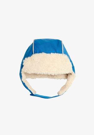 Plava zimska kapa s mekim, kremastim umjetnim krznom. Ima zaobljeni vrh i ušne flapove, osigurane podesivim trakama.