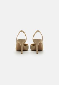 Beige high-heeled shoes featuring a textured glittery material, open back, and a slender stiletto heel. Smooth inner lining.
