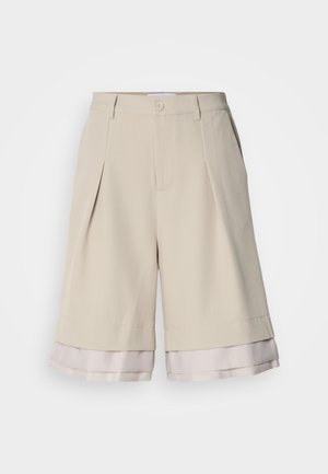 Bermudas em bege com pregas, apresentando uma bainha em cetim de um bege claro. O material é suave com um acabamento nítido.