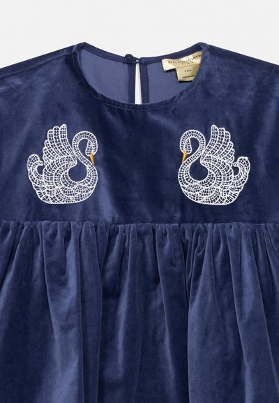 Navyblå fløjls kjole med rund halsudskæring, knaplukning og symmetriske hvide broderede svaner med gule næb på brystet.