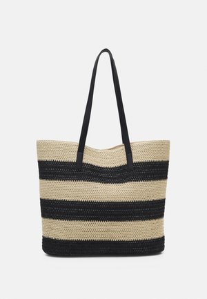 Bolso tote tejido con rayas beige y negras con asas largas negras, exhibido contra un fondo liso gris claro.