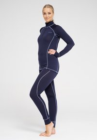 Marine bundsæt lavet af blødt, strækbart stof med en kvart lynlås krave. Har kontrasterende lysegrå sømme og tætsiddende design.