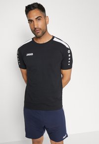 Zwarte sport T-shirt met korte mouwen, witte schouderstrepen en ronde hals. Bevat een logo en ronde accenten op de mouwen.