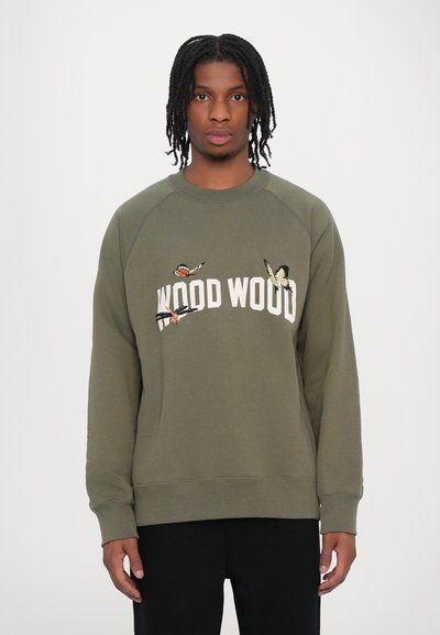 Sweatshirt vert olive avec un col rond, des poignets côtelés et des détails de papillon brodés. Le nom de la marque "WOOD WOOD" apparaît en blanc.