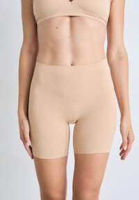Beige naadloze korte shorts met een gladde textuur, voorzien van een hoge taille en een aansluitend ontwerp, geschikt voor lagen of sportkleding.