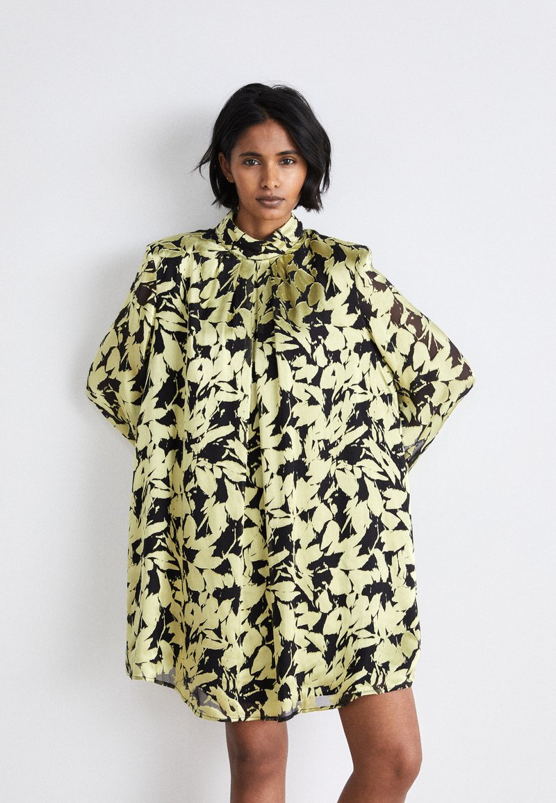 Rochie florală cu guler; material ușor, transparent, cu modele de frunze galbene și negre; siluetă lejeră cu mâneci largi.