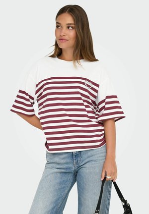 Gestreept T-shirt met een wit en bordeauxrood design. Kenmerkt zich door een hartvormige versiering en losse korte mouwen. Combinatie met lichtblauwe denim.