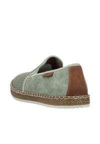 Scarpa slip-on caratterizzata da una tomaia in rete verde chiaro con texture simile alla pelle scamosciata, accentuata da dettagli in pelle marrone e rifiniture in juta intrecciata sulla suola.