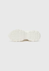Sole di sneaker bianca in gomma testurizzata, con un motivo a griglia per la trazione, punta arrotondata e un design minimalista pulito.