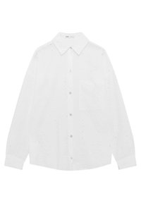 Chemise blanche à manches longues avec un col pointu, présentant des détails découpés et une poche avant. Fabriquée en tissu léger, boutonnée à l'avant.