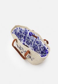 Kudottu olkilaukku, jossa ruskeat nahkahihnat; sisäpuolella sinivalkoinen painettu kangas, jossa kukka- ja vesiaiheisia kuvioita.