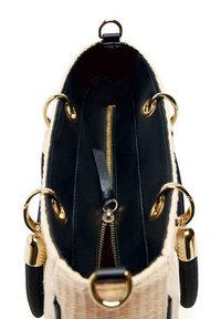 Gran bolsa tote con exterior de mimbre y interior de cuero negro. El hardware dorado incluye anillas y detalles en la cremallera. Diseño estructurado con asas dobles.