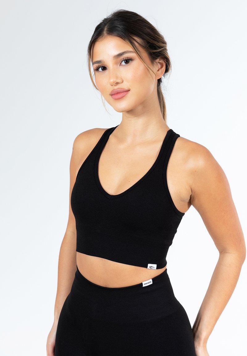 Zwarte geribde crop top met een diepe V-hals, brede bandjes en een aansluitend ontwerp. Bevat een klein merketiket aan de zoom.