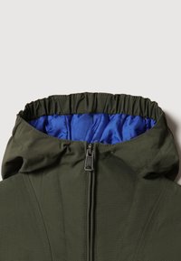 Hoodie-jacka med en olivgr�ön utsida och en blå vadderad foder, med dragkedja fram och en rynkad krage för en snug passform.