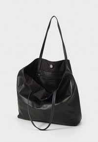 Črna usnjena torba z dvema podolgovatima ročajema, prostorno notranjostjo, notranjim žepom z zadrgo in magnetnim zapiranjem.