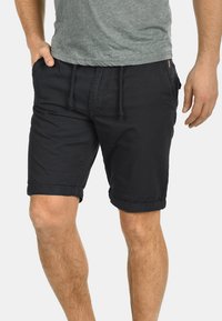 Bermudas de algodón azul marino con un corte relajado, cintura con cordón y dobladillos rematados. Presenta bolsillos laterales y una textura suave.