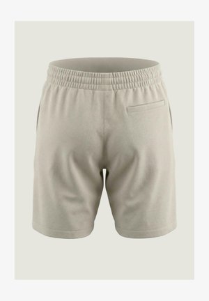 Short beige clair avec taille élastique, poches latérales et une seule poche passepoilée arrière, présenté de dos sur un fond uni.