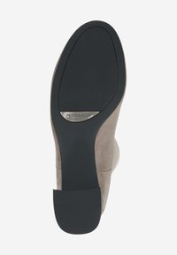 Bottines en suede beige avec une semelle plate en caoutchouc noir. Présentent un petit talon et une plaque logo métallique portant la mention "PETER KAISER."