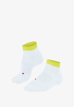 Calzini bianchi alla caviglia con un risvolto giallo brillante, caratterizzati da un piccolo logo rosso vicino alla punta, esposti su uno sfondo bianco uniforme.