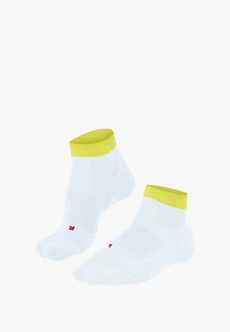 Białe skarpetki do kostek z jaskrawą żółtą mankietą, z małym czerwonym logo w pobliżu palców, wyeksponowane na gładkim białym tle.