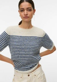 Pull en maille rayé avec une palette de couleurs crème et bleu marine, manches courtes, col rond et tissu texturé.