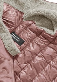 Wnętrze kurtki ocieplanej z miękkim, beżowym, sztucznym futrem oraz błyszczącego, różowego, pikowanego materiału. Zawiera czarną metkę marki.