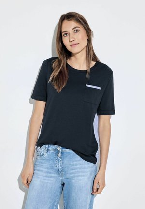 T-shirt noir à manches courtes avec une poche rayée, en tissu doux, à encolure ronde et à coupe décontractée, associé à un jean en denim bleu clair.