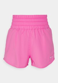 Vaaleanpunaiset urheilushortsit, joissa on rypytetty vyötärö, pehmeä kangas ja pieni valkoinen Nike-logo helmassa. Sujuva pinta, ei kuvioita.
