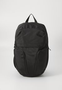 Zaino in nylon nero con due tasche laterali, maniglia superiore e finitura liscia. Presenta un scomparto principale con zip e un design minimalista.