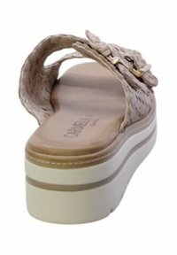 Sandal in paglia intrecciata di colore beige con una robusta suola piatta bianca, caratterizzato da una striscia stretta e un elegante dettaglio in metallo dorato.