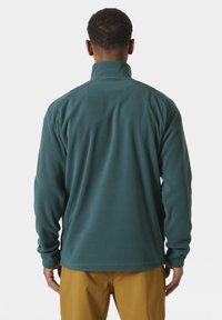 Polarowa kurtka w ciemnym odcieniu zieleni z wysokim kołnierzem. Posiada długie rękawy i gładką powierzchnię. Widok z tyłu nie pokazuje żadnych logotypów ani wzorów.