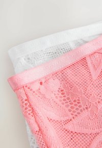 Set med två spetsunderkläder, en vit och en rosa. Inkluderar blommönster, spetsstruktur och satinsmidda midjeband i matchande färger.