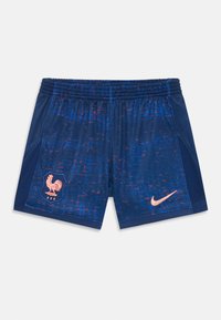 Tengeri kék sportnadrág piros és kék pöttyös mintával. Bal oldalon kakas emblémával és rózsaszín Nike logóval rendelkezik. Rugalmas derékpánt.