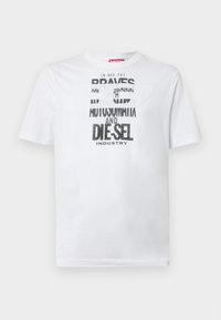 Tricou alb din bumbac cu tipografie neagră îndrăzneață, cu cuvintele "BRAVES" și "DIE-SEL INDUSTRY" și un design decupat semi-transparent.