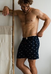 Boxer shorts blu navy realizzati in tessuto morbido, con un motivo ripetuto di biciclette e una cintura elastica con un piccolo dettaglio rosso.