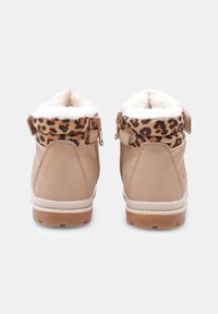 Botas de tobillo marrones con un puño de estampado de leopardo y forro de piel sintética blanca. Cuenta con cremallera lateral, suelas texturizadas y material de ante suave.