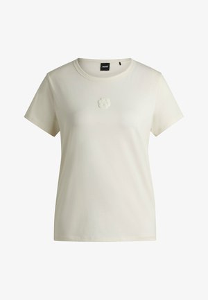 White cotton t-shirt with a round neckline and short sleeves. Features a soft textured logo on the chest. Straight hem.