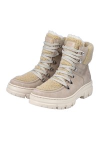 Bottes d'hiver beiges à lacets avec semelles blanches épaisses et doublure en peau de mouton moelleuse, conçues pour la chaleur et une utilisation en extérieur.