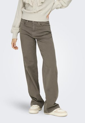Pull crème ajusté avec détail volants, associé à un jean large olive. Les jeans comportent des poches avant et un design classique à cinq poches.